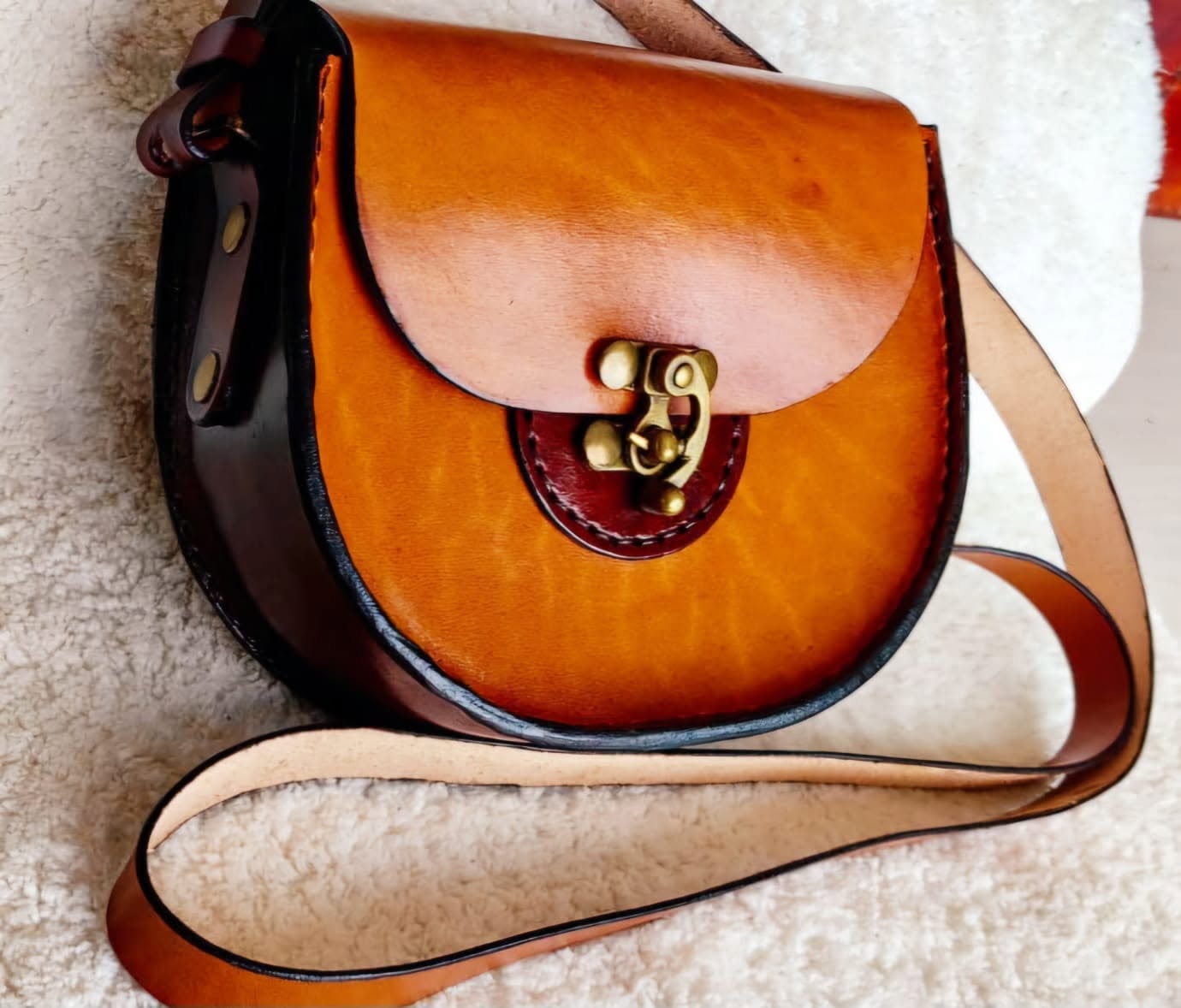 Two-tone leather satchel with a brass clasp