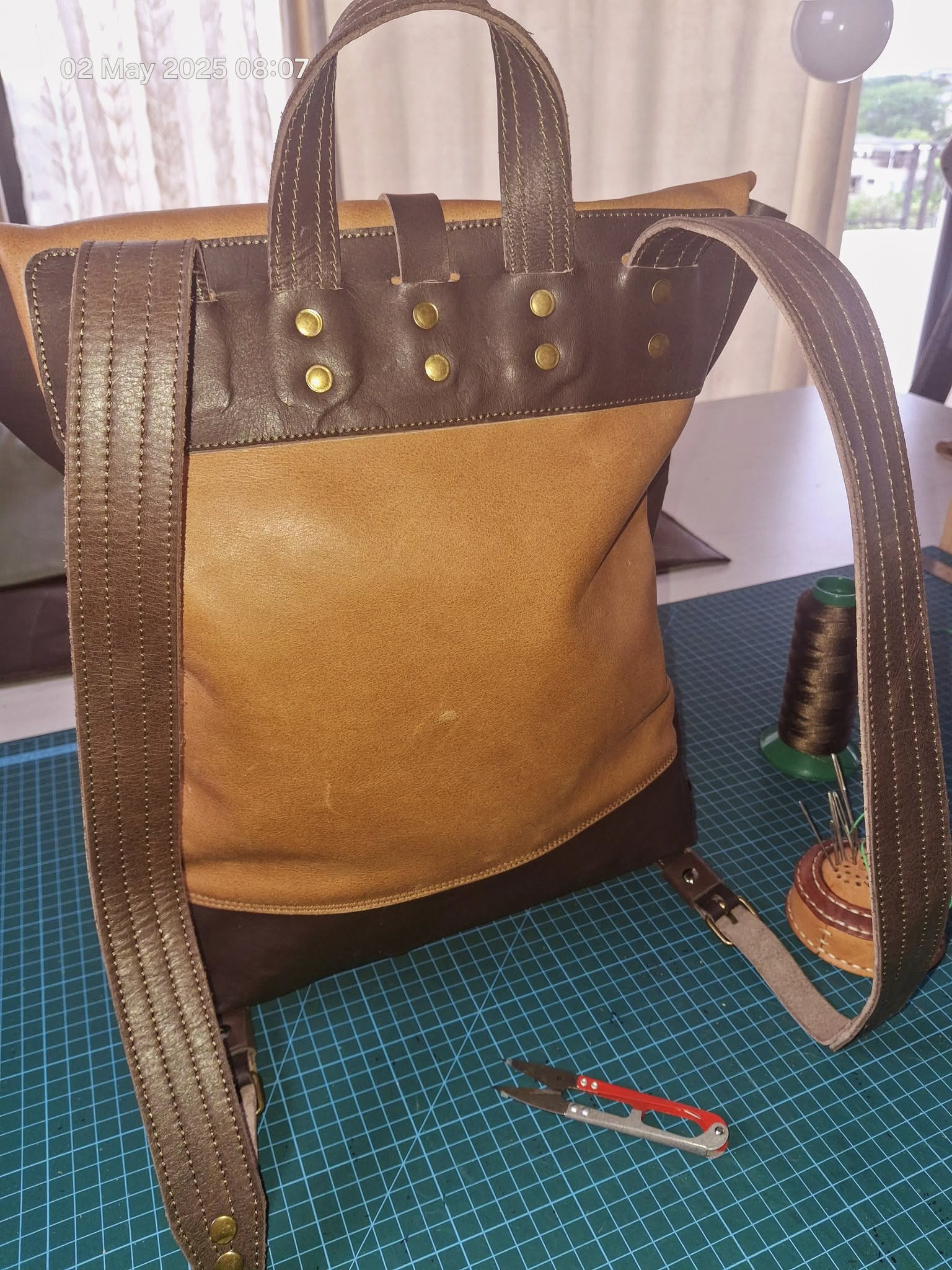 Tan leather tote bag with riveted handles