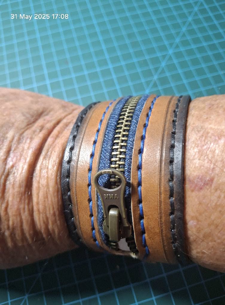 Leather cuffs and a stitched zip wristband worn on the wrist
