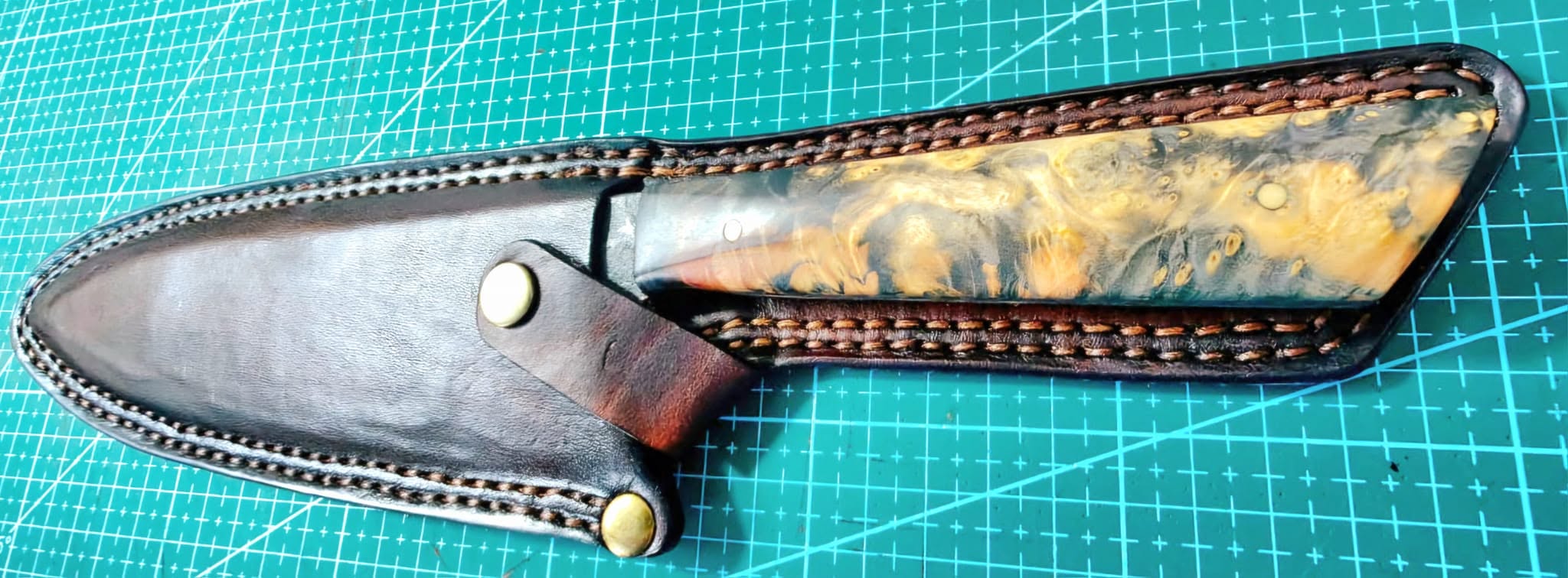 Two hand-stitched leather knife sheaths side by side