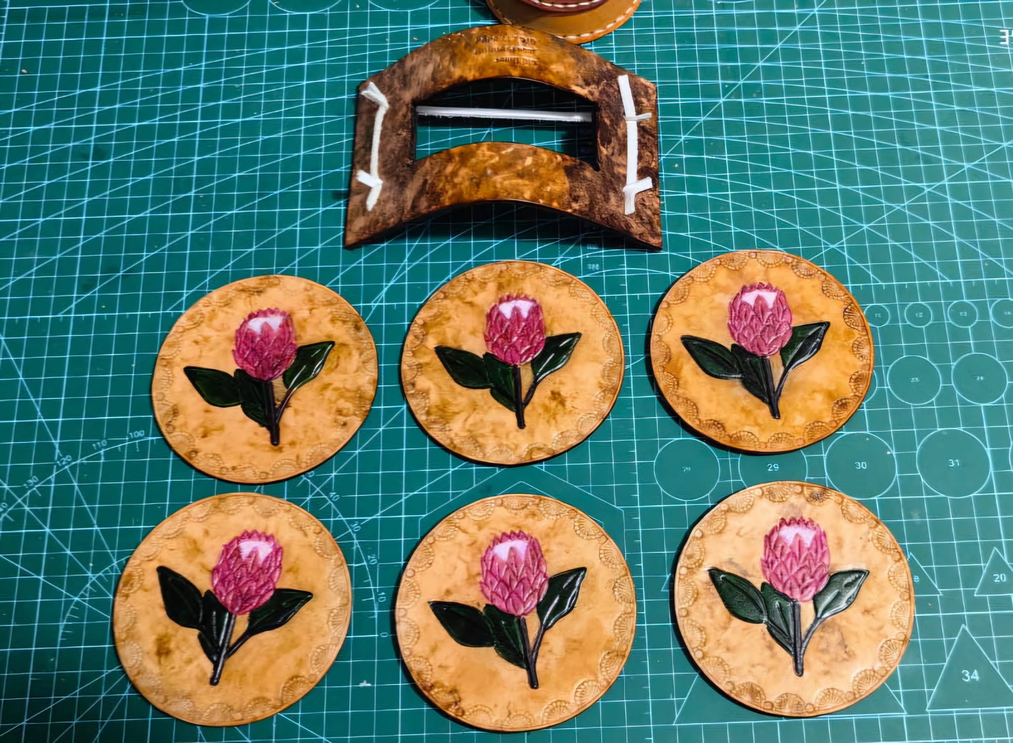 Round leather coasters painted with red flowers