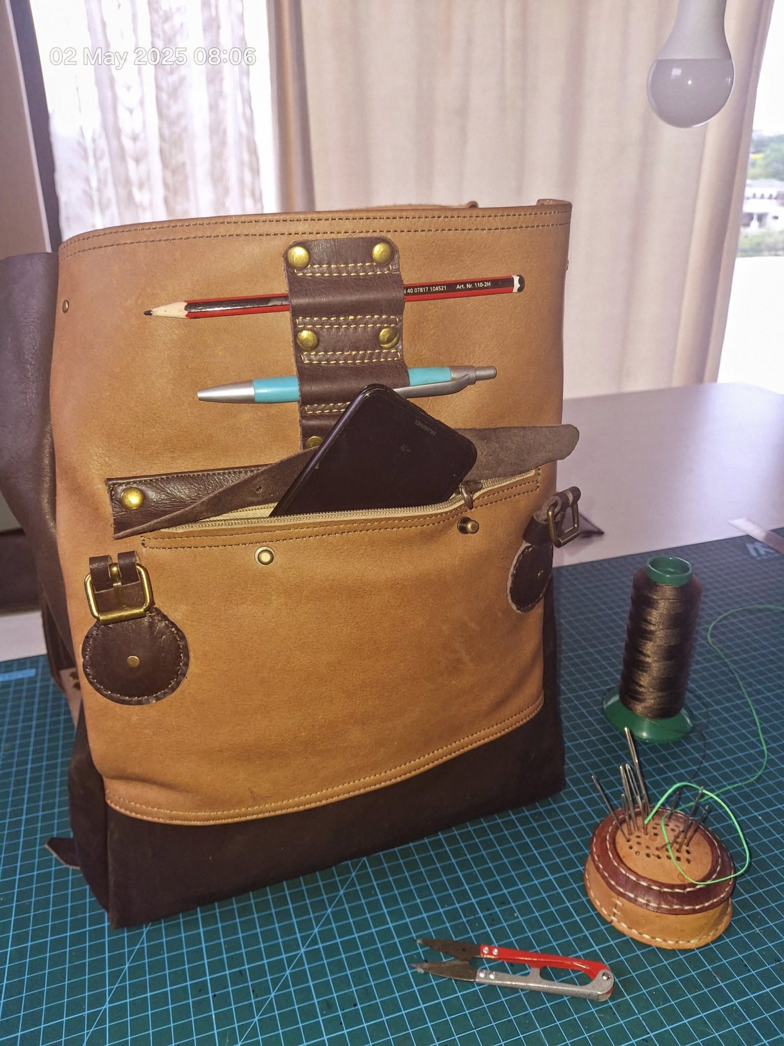 Open tan leather tool roll with stitched pockets