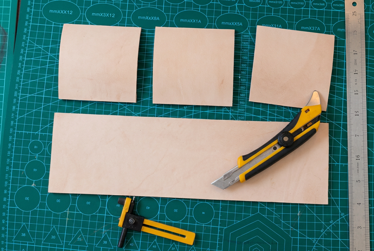 Leather panels, a cutter and a ruler on Jaco's cutting mat
